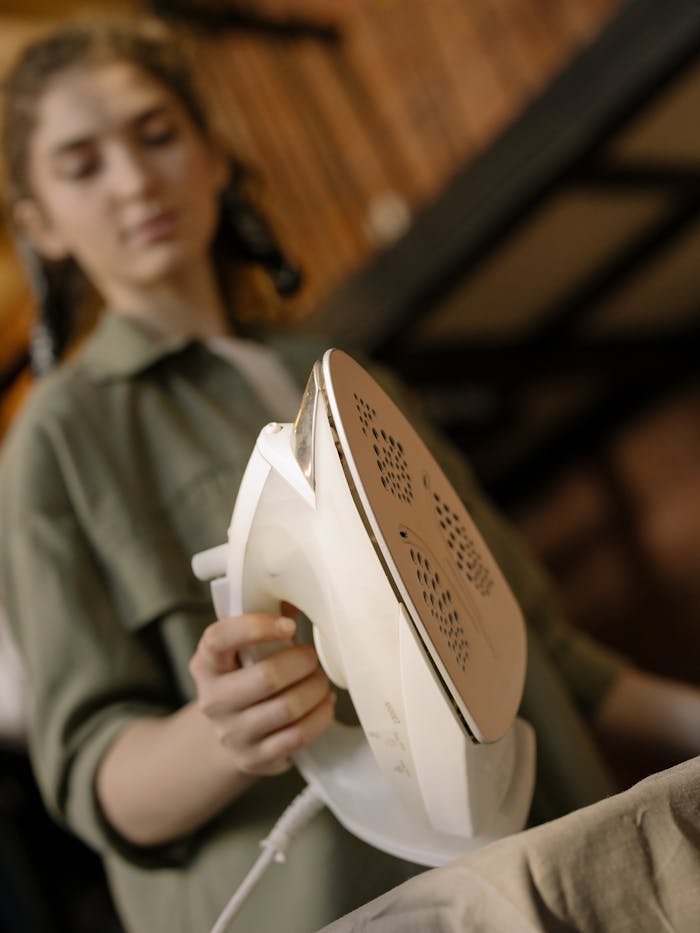 A woman ironing clothes at home, focusing on the domestic task of keeping clothes neat.